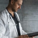 Portrait of a confident male doctor using a tablet indoors.